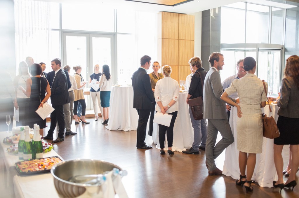 Group of conference participants hanging out in the lobby of the conference center during their lunch break